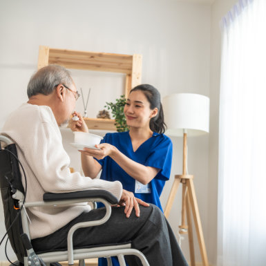 carer serving food to an elderly