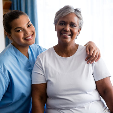 senior woman and healthcare worker smiling