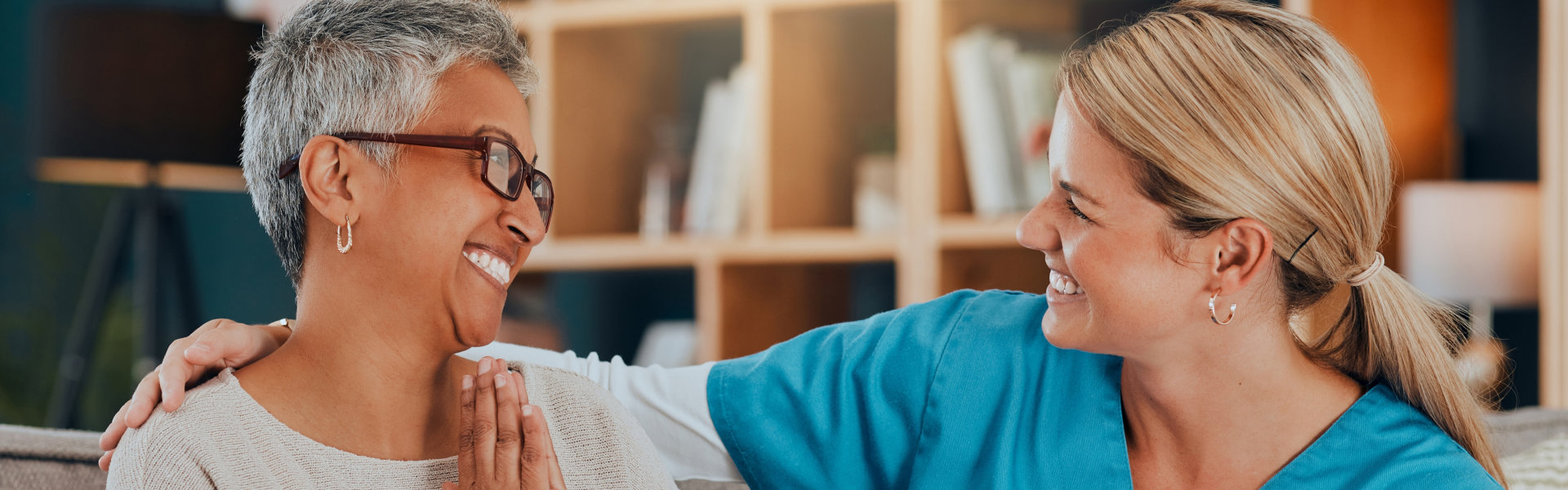 carer and senior woman smiling at each other